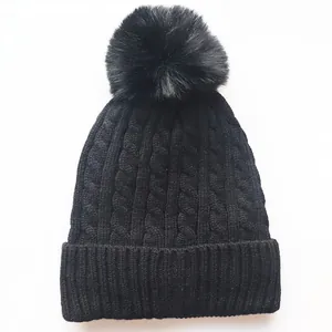 Soft black cable knit beanie for winter with faux fur pom-pom and ribbed cuff