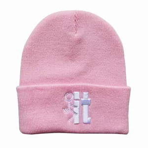 Detailaufnahme der pinkfarbenen Strickmütze mit weißem Stickmotiv im Streetwear-Stil