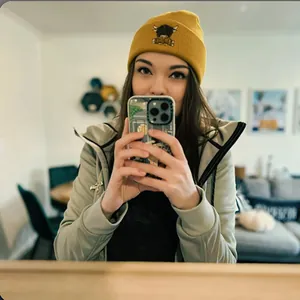 Gelbe Strickmütze mit Highland-Kuh-Stickerei kombiniert mit grünem Kapuzenpullover im Alltag
