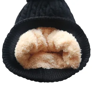 Black cable knit beanie with faux fur lining and pompom for winter warmth