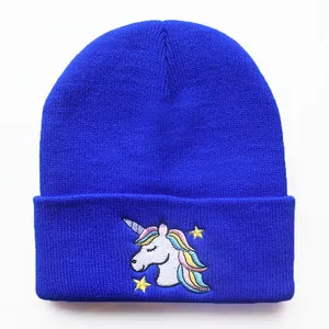 Detail der Einhorn-Stickerei auf blauer Strickmütze mit Regenbogenmähne und Sternen