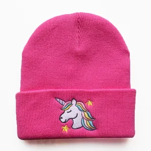 Detail der pinkfarbenen Strickmütze mit Einhorn-Stickerei und gerippter Textur