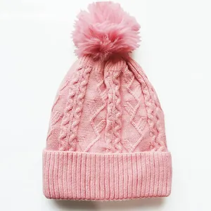 Rosa Damen Strickmütze mit Zopfmuster und Kunstfellbommel für warme Wintertage im Freien