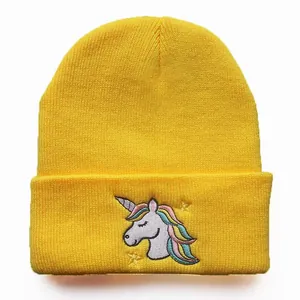 Detail einer gelben Strickmütze mit farbenfroher Einhorn-Stickerei und gelben Sternen