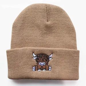 Detail einer braunen Strickmütze mit hochwertiger Highland-Cattle-Stickerei für den Winter