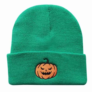 Detailansicht der Kürbis-Stickerei auf der leuchtend grünen Strickmütze für Halloween
