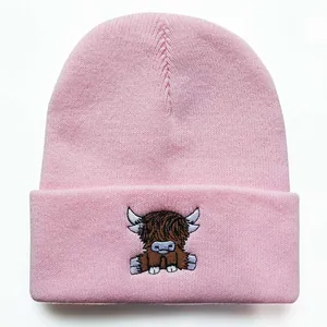 Detailaufnahme einer rosa Strickmütze mit einer hochwertigen Hochlandrind-Stickerei darauf