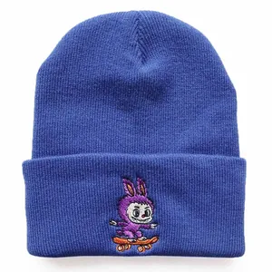 Detail of navy knit beanie featuring high-quality embroidery of a monster on a skateboard