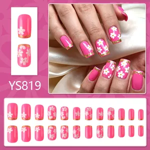 Faux ongles roses avec motifs de fleurs blanches et pointes french dorées 24 pièces
