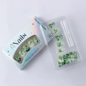 Makroaufnahme von St. Patrick's grünen Kunstnägeln in holografischer Verpackung