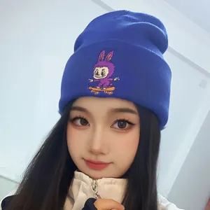 Navy blue knit beanie with purple cartoon rabbit on skateboard worn by a model