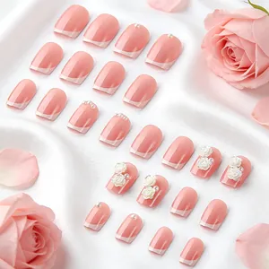Detail of French pink press-on nails with 3D white roses and pearls on satin