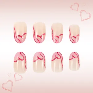 Detail of almond-shaped press-on nails with pink French tips and red heart line art