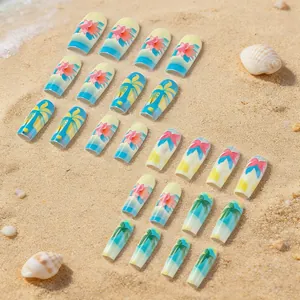Close-up of tropical summer press-on nails with palm tree and hibiscus on beach sand