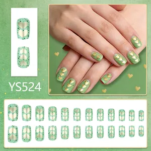 Square avocado green press-on nails with golden heart design and splatter pattern