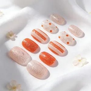 Faux ongles carrés courts avec motifs orange et blanc sur fond en satin blanc soyeux