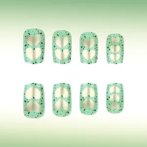 Detail of square mint green press-on nails with golden hearts and emerald stone marble texture