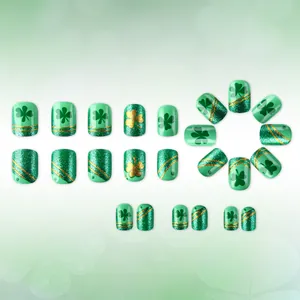 Detailed close-up of St. Patrick's Day false nails with green clovers and gold glitter