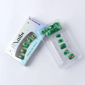 Detail view of St. Patrick's Day press-on nails with green glitter and clover patterns