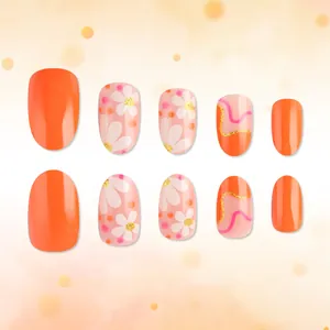 Short oval orange press-on nails with daisy flower patterns and golden glitter accents