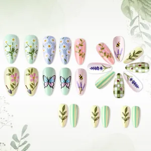Detailed view of almond green press-on nails with floral, butterfly, and lavender patterns