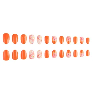 Short oval orange press-on nails with daisy floral prints and gold glitter accents