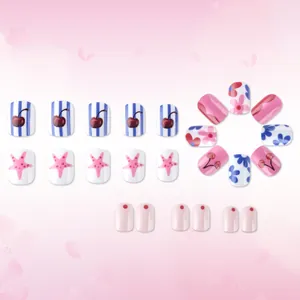 Detail of short square press-on nails with pink floral, cherry, and star patterns