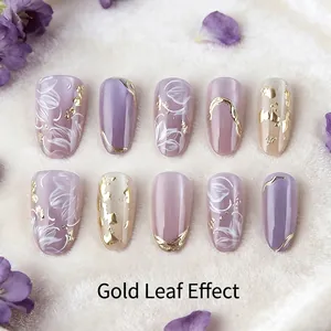 Purple almond press-on nails set with gold foil accents and hand-painted white floral motifs