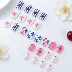 Detail of short square press-on nails with pink flowers, cherries, and stripe patterns