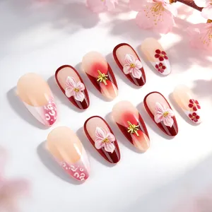 Unghie finte 3D con fiori di ciliegio sfumati rosa e rilievi floreali con dettagli dorati