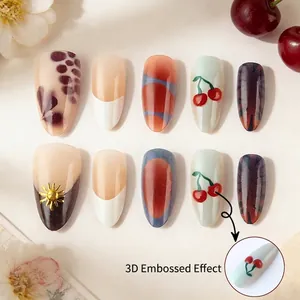3D relief press-on nails with cherry motifs and sun charms in red and cream hues