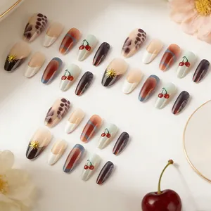 Medium almond press-on nails with red cherry, leopard print, and 3D metal sun charms