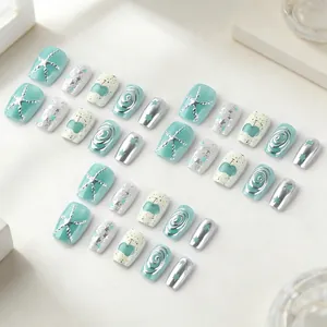Short square press-on nails in mint green and silver glitter with 3D starfish design