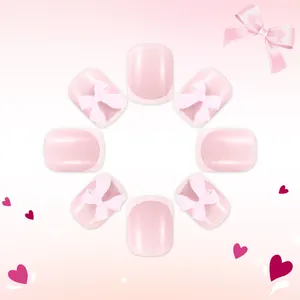 Dettaglio di unghie finte French rosa con fiocchi 3D bianchi e finitura lucida professionale