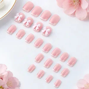 Dettaglio delle unghie finte rosa stile francese con fiocchi 3D e finitura lucida