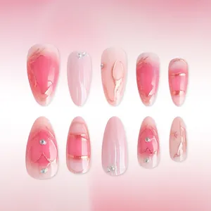 Pink gradient almond press-on nails with rose gold lines and rhinestone heart accents