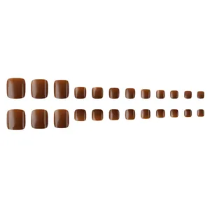24 pieces of glossy caramel brown press-on toenails in various sizes on white background