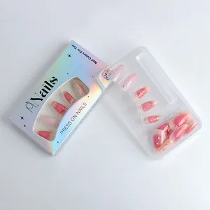 Detailed view of almond press on nails with pink gradient, gold lines and rhinestones