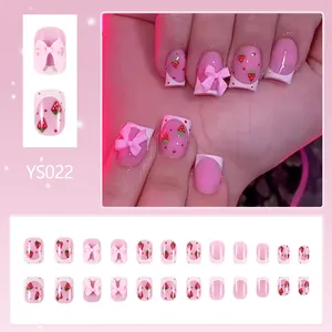Short glossy press-on nails with 3D pink bows, strawberry patterns, and French tips