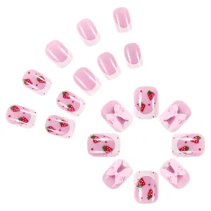Short pink press-on nails with strawberry patterns and 3D bow accents in French style