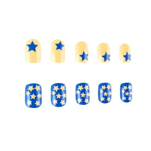 Detail view of short round press-on nails with yellow and blue star patterns on white base