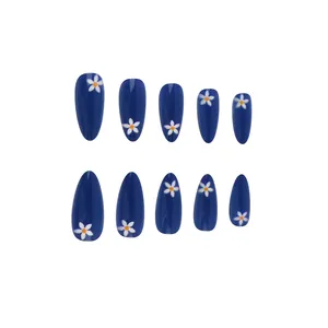 Detailed top view of short almond glossy blue press-on nails with white daisy patterns