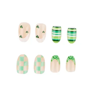 Detail of oval press-on nails with green heart, stripes, and checkerboard patterns