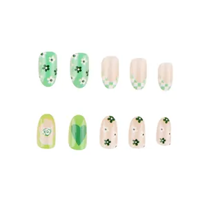 Macro detail of 10-piece green floral and checkerboard press-on nails with heart patterns