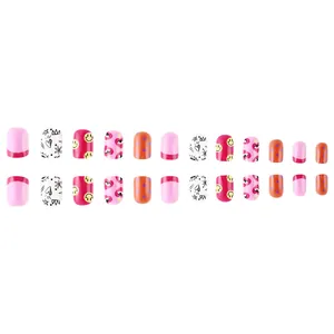 Flat lay of glossy fake nails featuring colorful smiley faces and heart patterns