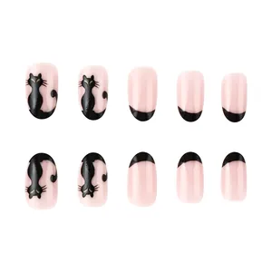 Detail of pink almond fake nails with black cat silhouettes and French tip designs