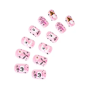 Dettaglio di unghie finte rosa per Halloween con motivi carini di fantasmi e zucche