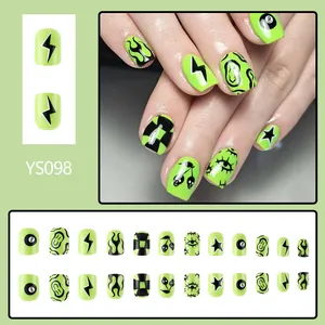 Short green press-on nails with black graffiti designs like lightning and fire