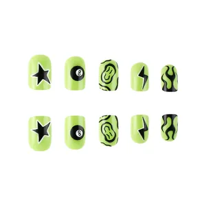 Detail of neon green and black press-on nails with 8-ball, star, and lightning designs