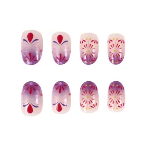 Detail of short French press-on nails with purple floral patterns and gold accents